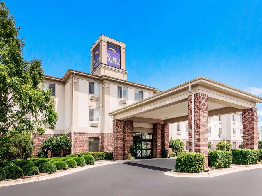A Sleep Inn & Suites hotel with a clear entrance, brick facade, and a sign on the roof.