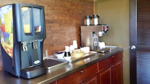 A coffee machine, a small refrigerator, and a counter with various items. - Recreation Inn & Suites (Kelowna)