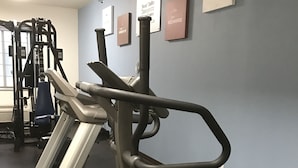 A gym with treadmills and weight machines, a blue wall with motivational signs, and a window with natural light. - Hawthorn Extended Stay by Wyndham Amarillo (Amarillo)