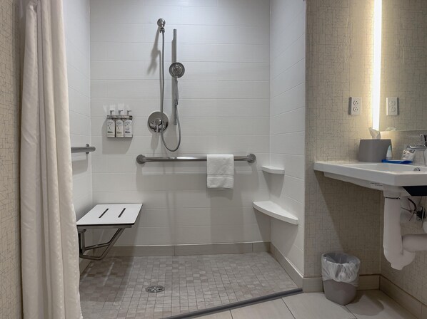 A modern bathroom with a shower, toilet, and sink.
