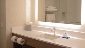 A hotel bathroom with a large mirror, a sink, and two rolls of toilet paper. - Holiday Inn Express Hotel & Suites Livermore by IHG (Livermore)
