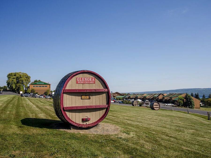 Un'ampia botte di legno con la scritta "Glenora Wine Cellars" in un prato, sullo sfondo un edificio e degli alberi.