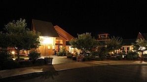 A well-lit hotel with a prominent entrance, landscaped gardens, and a clear driveway. - The Inn at Glenora Wine Cellars (Dundee)