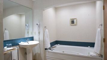 Une salle de bain avec un lavabo, un miroir et une baignoire.