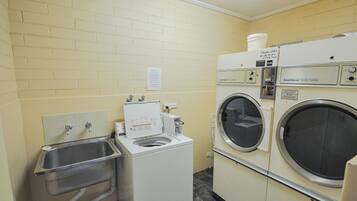 Un cuarto de lavandería con lavadora, secadora y lavabo.