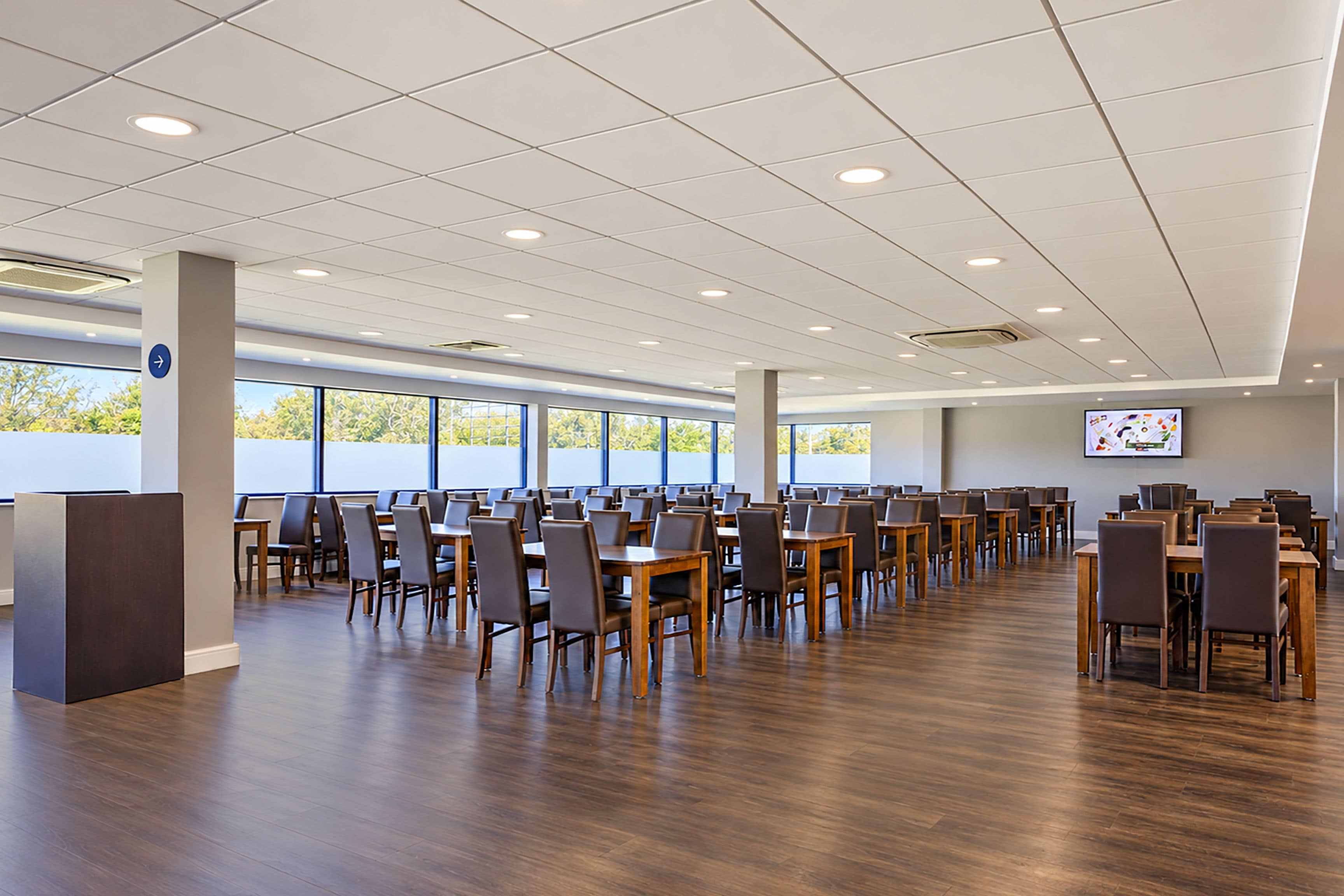 Un espace intérieur spacieux, aménagé avec plusieurs tables et chaises, idéal pour les repas ou les réunions.