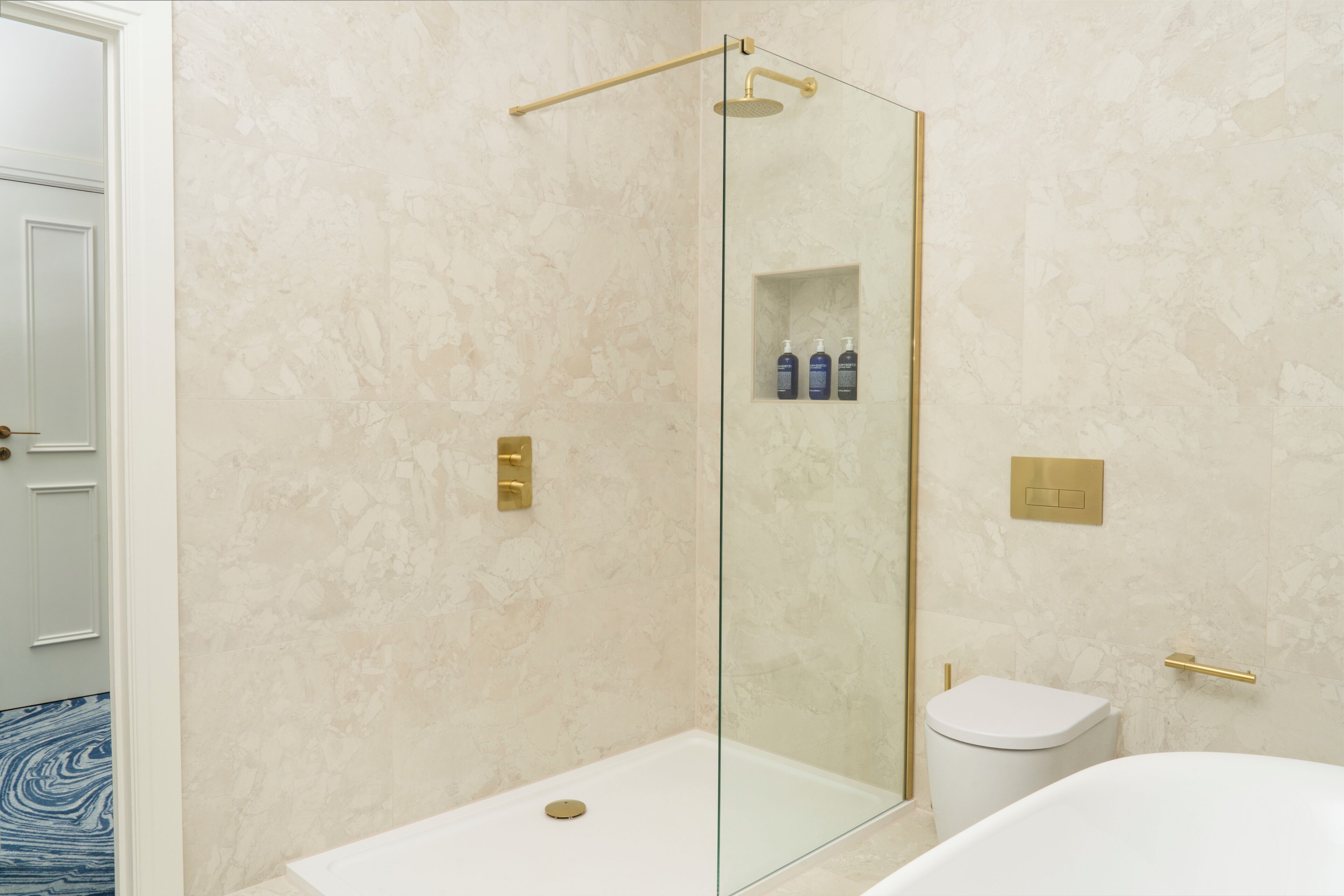A modern bathroom with a glass-enclosed shower, a toilet, and a sink.