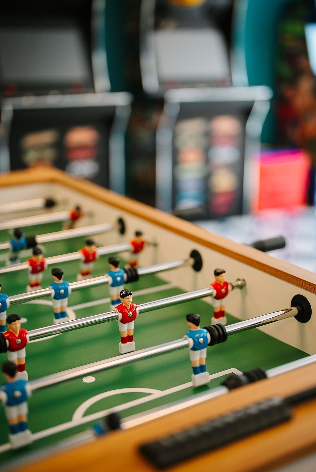 Een tafelvoetbaltafel met miniatuurfiguurtjes in rode en blauwe tenues.