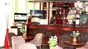 A bar area with seating, a television, and a variety of bottles and glasses on shelves. - Elizeu (Bucharest)