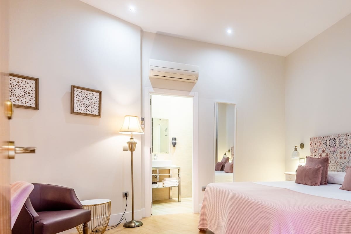 Une chambre d’hôtel avec un lit, une table de chevet, une lampe et une chaise.
