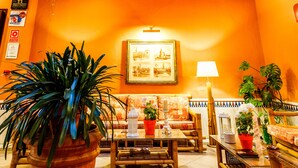 A hotel lobby with a high ceiling, a glass skylight, and a balcony with potted plants. - Hotel Patio de la Alameda (Seville)