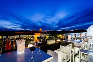 An outdoor dining area with tables and chairs, a decorative lantern, and wine glasses. - Hotel Patio de la Alameda (Seville)