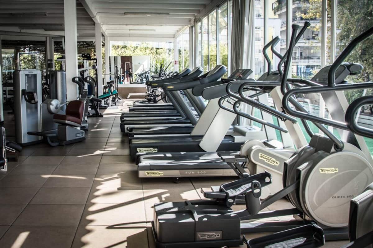 Un gimnasio con cintas de correr, elípticas y equipos de pesas.