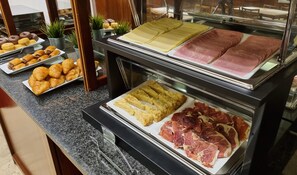 A buffet with various food items including pastries, meats, and cheeses. - Hotel Gran Legazpi (Madrid)