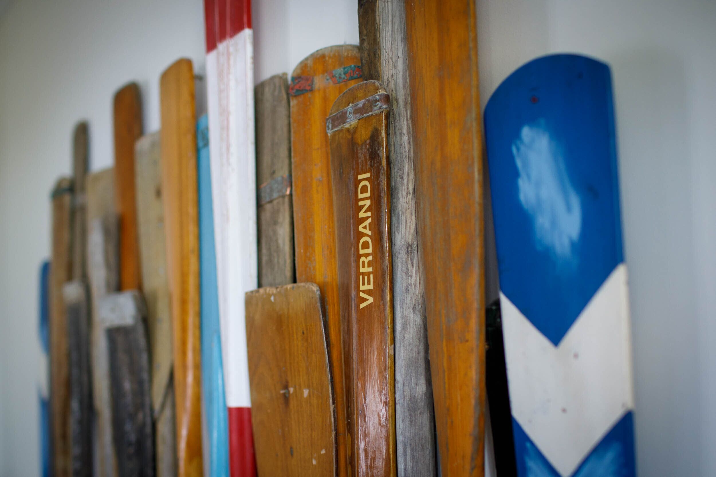 Een rij houten roeiblad(en), waarvan één het woord 'VERDANDI' heeft.