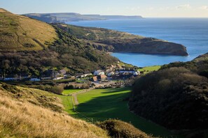 A coastal village with houses on a hillside overlooking the sea.