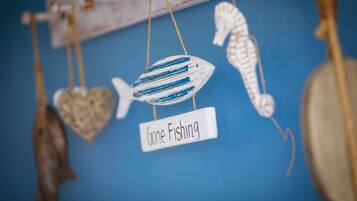 A wall with various fishing-themed decorations including a fish, a seahorse, and a heart-shaped ornament.