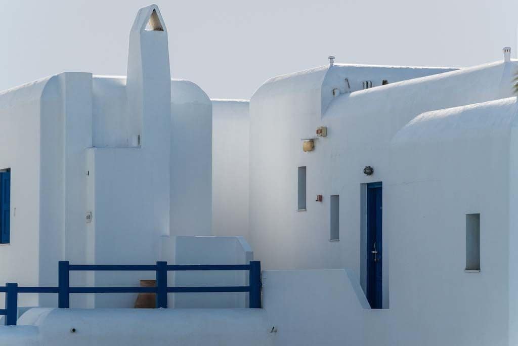 A white building with blue accents, including a door and windows.