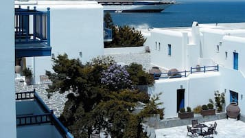 Un bâtiment situé sur la côte, doté d’une piscine, d’un balcon et offrant une vue sur un navire de croisière en arrière-plan.