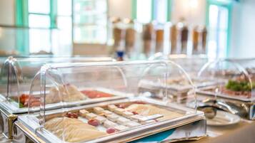 A buffet with various food items under glass covers.