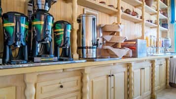 A kitchen with wooden shelves holding various kitchenware and a coffee station with multiple coffee makers.