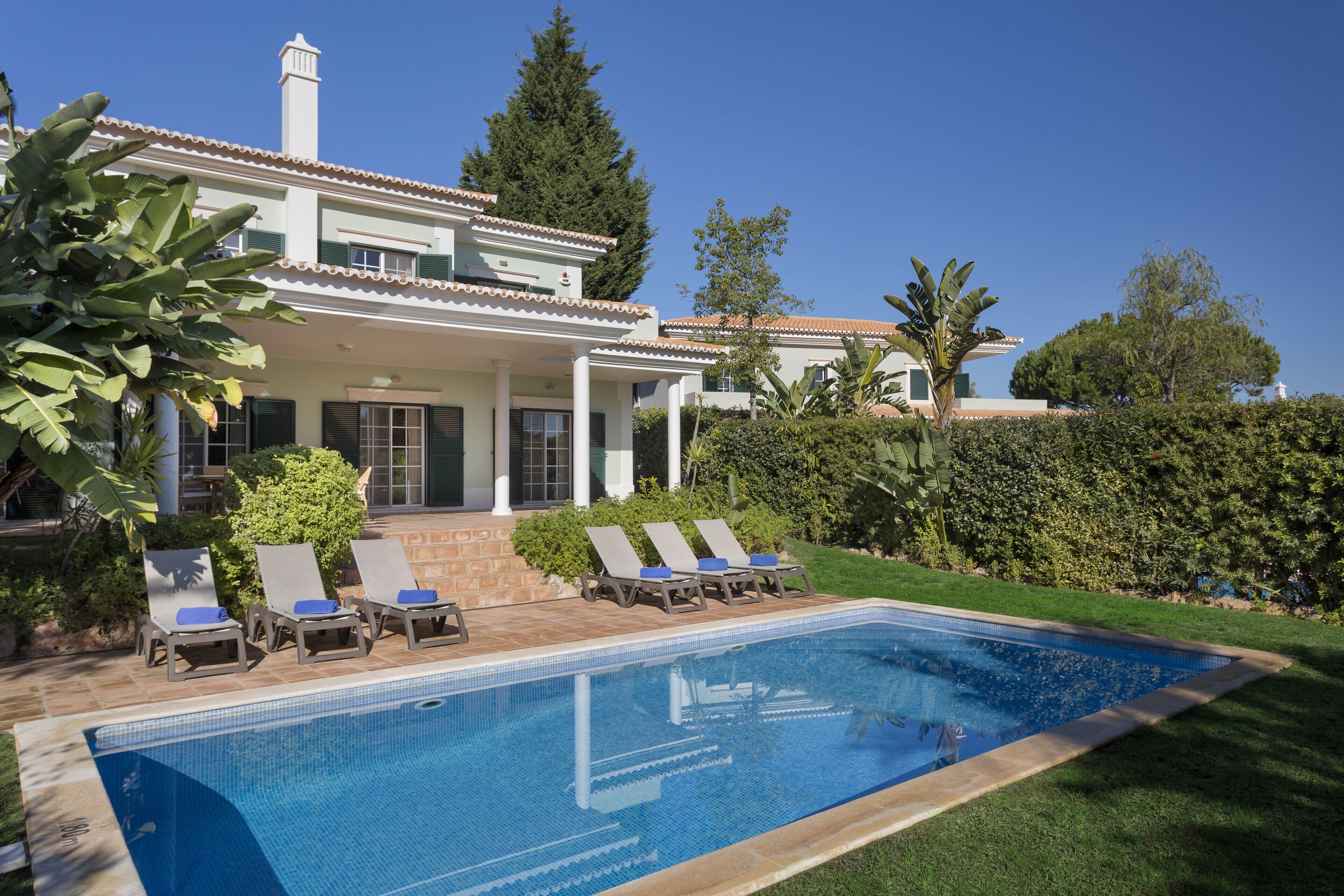 Un espace aménagé au bord de la piscine, avec des chaises longues et une piscine.