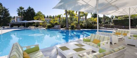 A pool area with lounge chairs and umbrellas.
