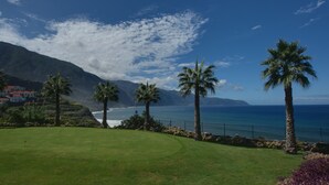 Un parcours de golf offrant une vue sur l’océan et les montagnes.