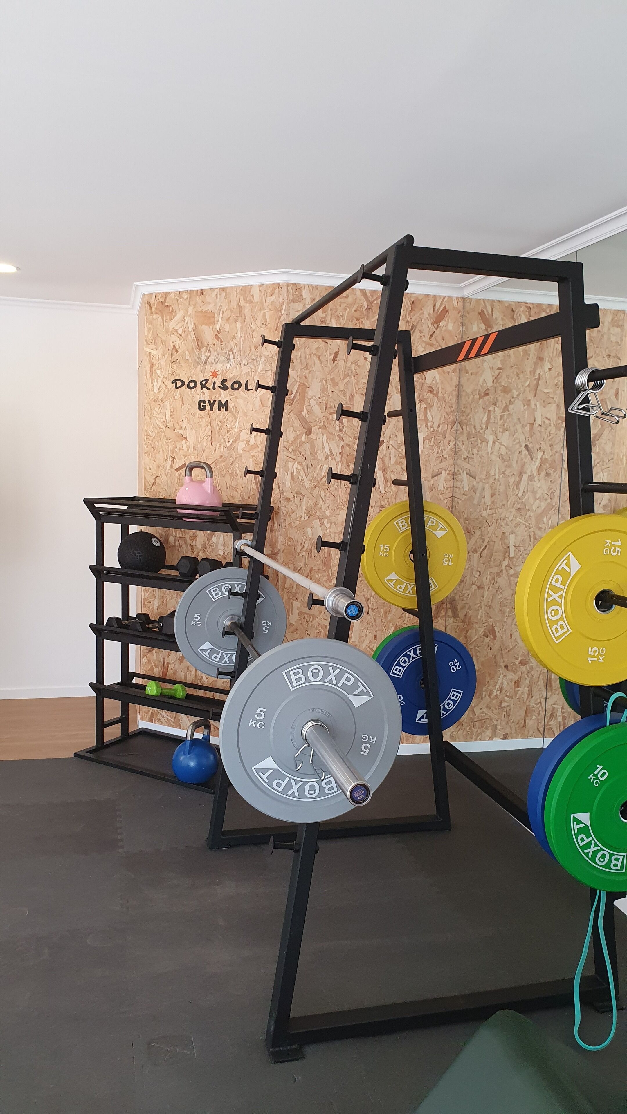 Ein Krafttrainingsbereich mit Squat-Rack, Langhantel und Gewichte.