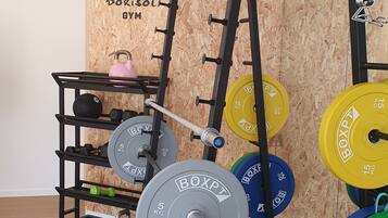 Ein Krafttrainingsbereich mit Squat-Rack, Langhantel und Gewichte.