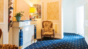 Una habitación con alfombra de diseño celeste con estrellas, una silla de madera, una estantería y una lámpara.