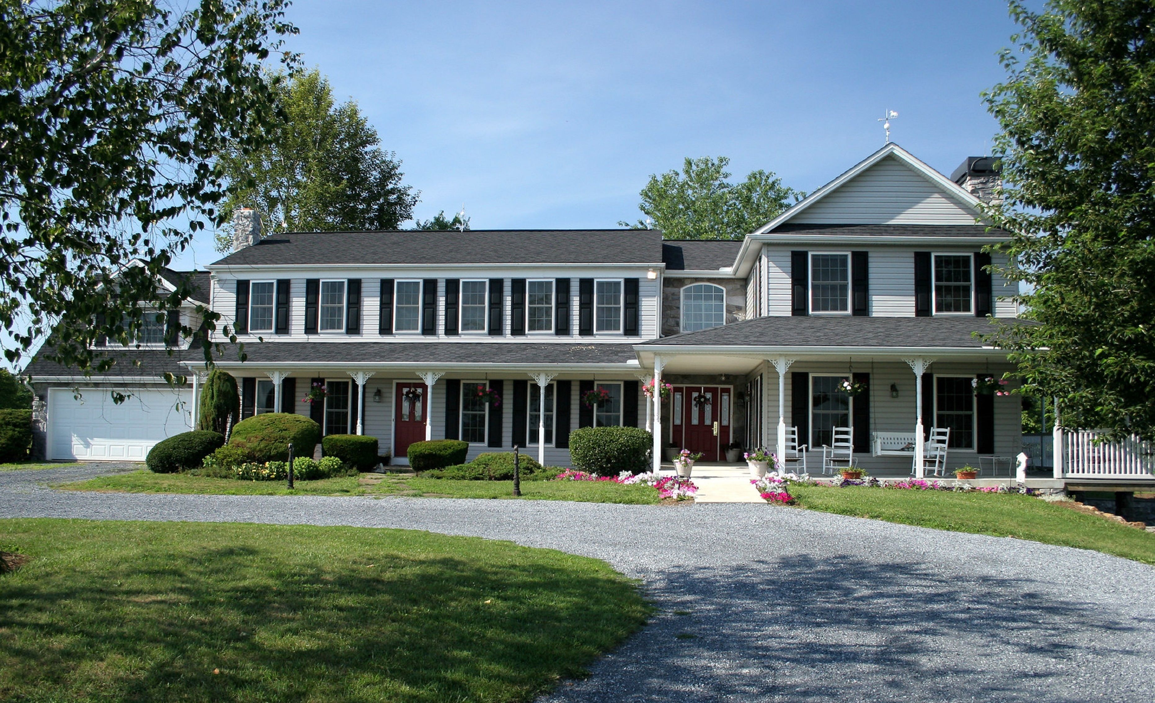 A two-story house with a front porch, a garage, and a well-maintained lawn.