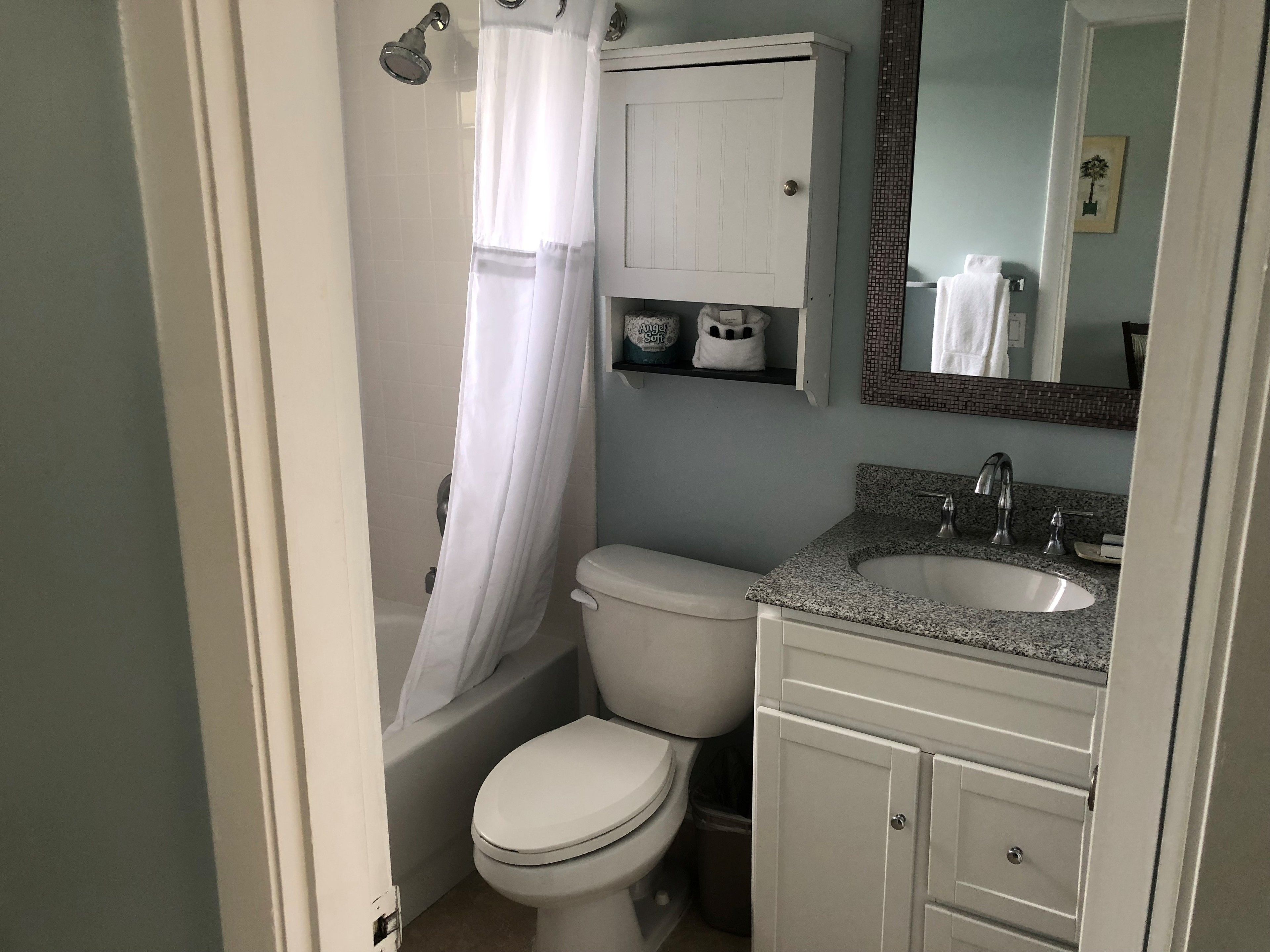 A bathroom with a toilet, sink, and shower.