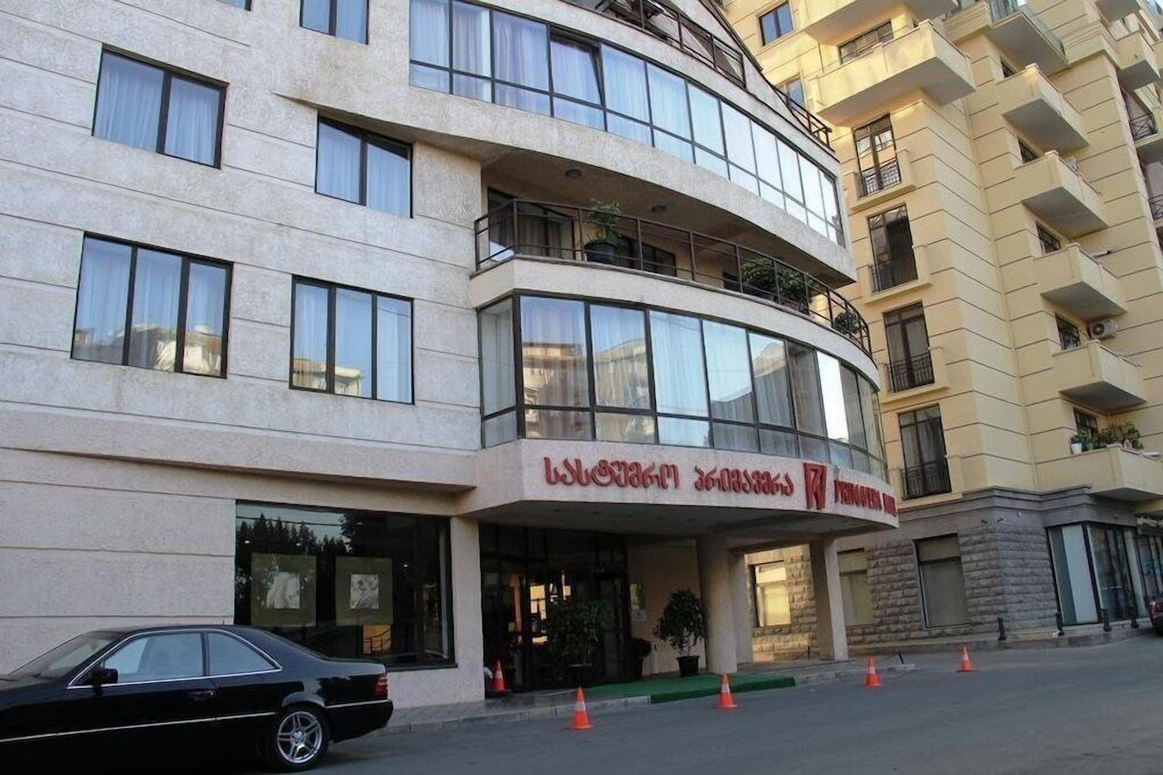 A multi-story hotel with a curved facade, large windows, and balconies.
