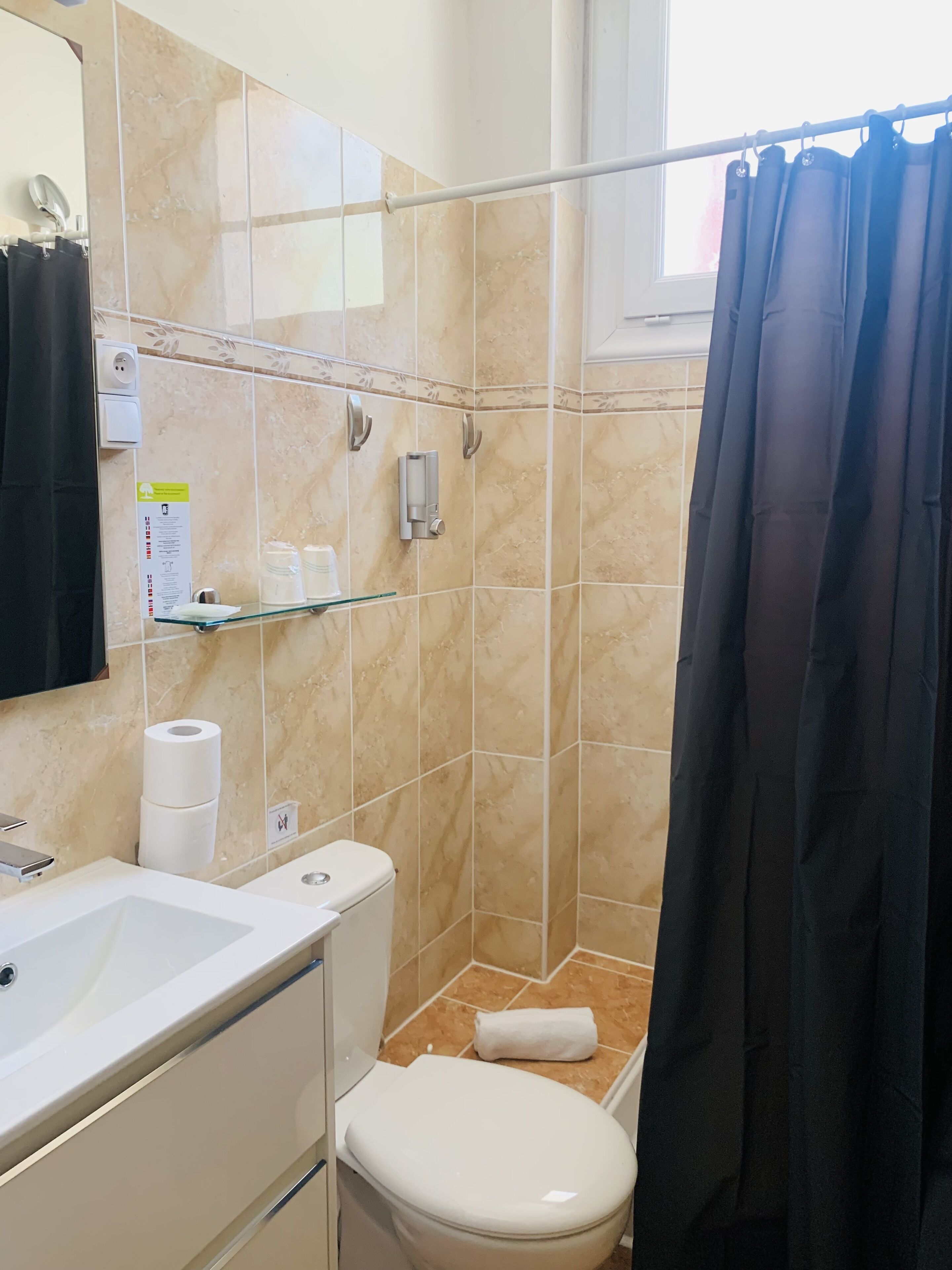 Un baño con inodoro, lavamanos y cabina de ducha.