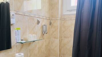 Un baño con inodoro, lavamanos y cabina de ducha.