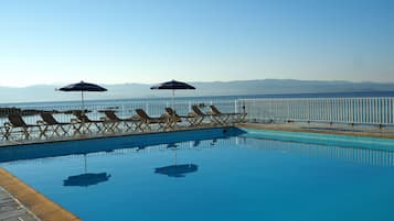 Piscine extérieure, parasols de plage, chaises longues