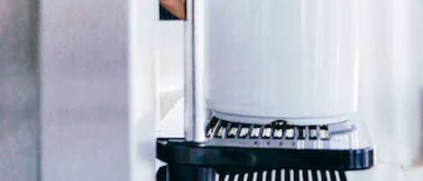 A coffee machine dispensing coffee into a clear glass cup.