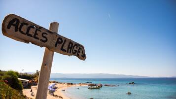 Een houten bord met de tekst 'ACCES PLAGES' dat naar een strand wijst.