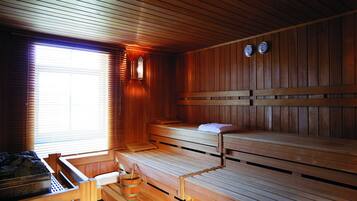 A sauna with wooden benches and a bench seat, a wooden bench with a towel, and a wooden bench with a towel.
