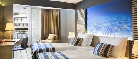Habitación de hotel con dos camas, un escritorio, una silla y un ventanal con cortinas.