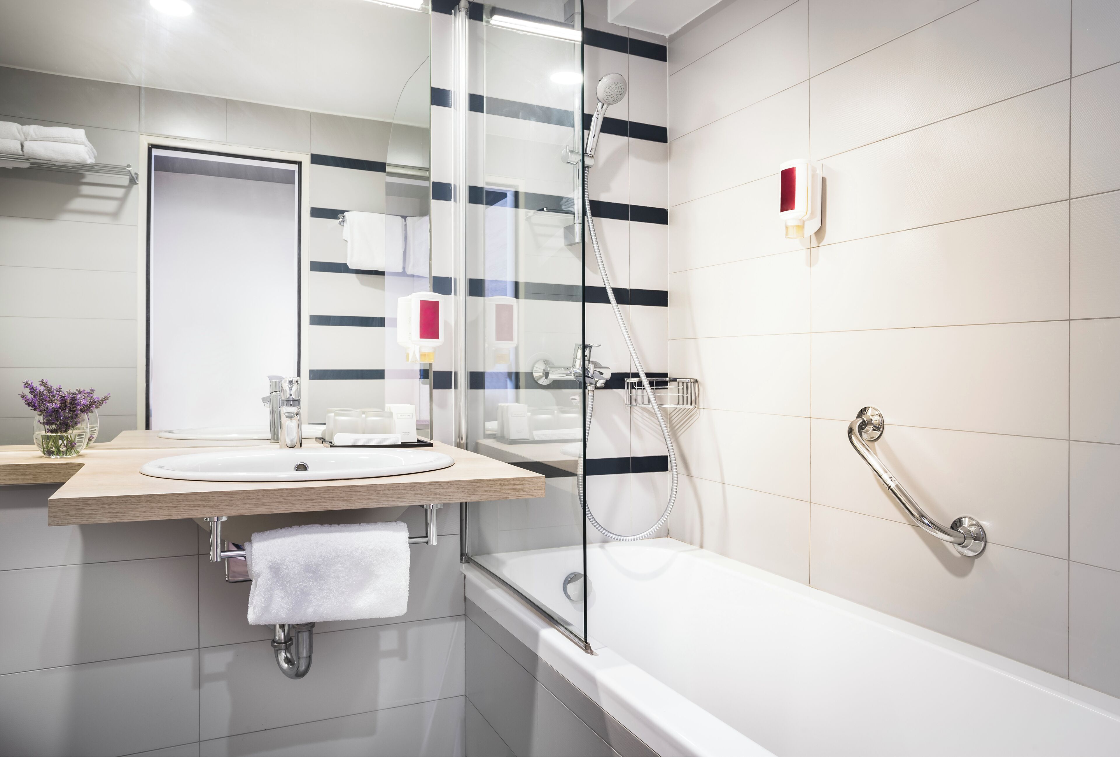 A modern bathroom with a bathtub, a shower, a sink, and a mirror.