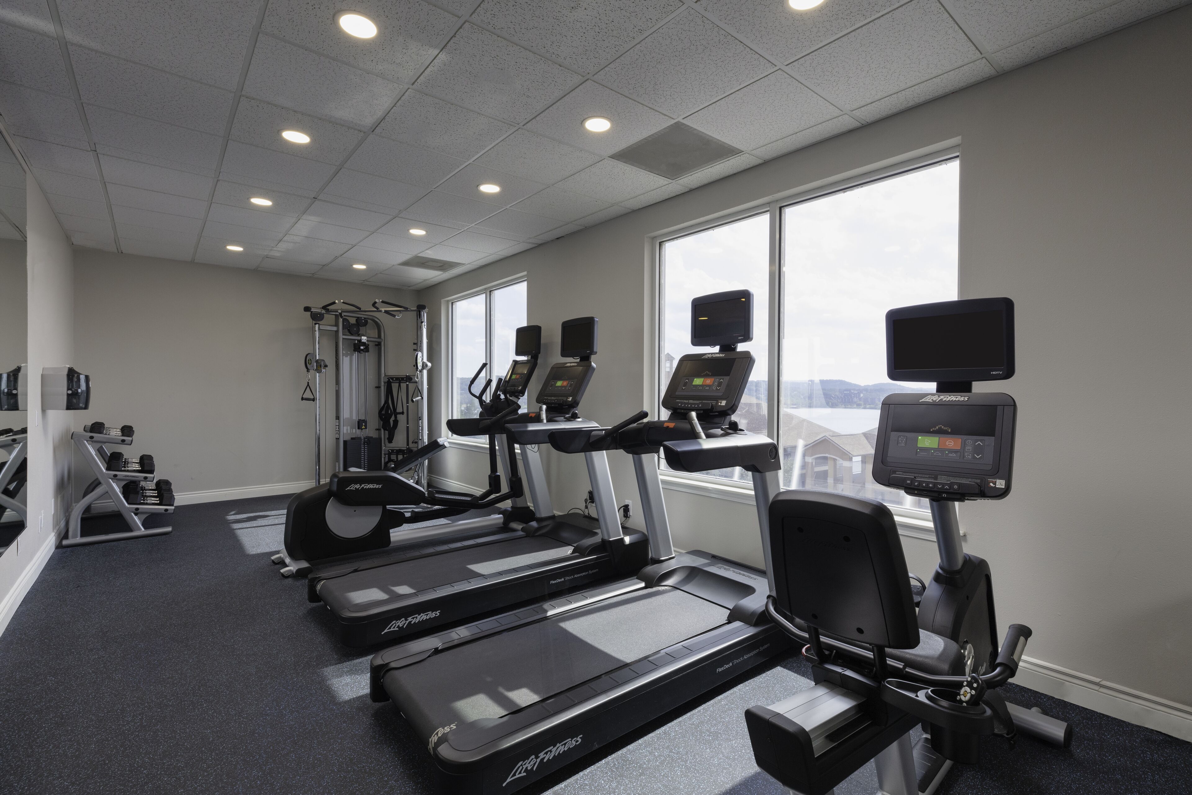 A gym with treadmills, elliptical machines, and weight equipment.