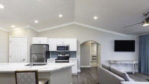 A modern kitchen with white cabinetry, a built-in microwave, and a stainless steel refrigerator. - Westgate Branson Lakes Resort (Hollister)