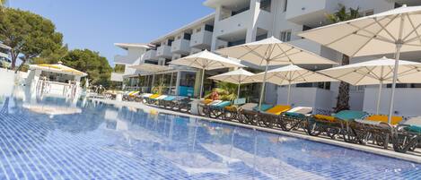 Una piscina al aire libre de temporada, sombrillas