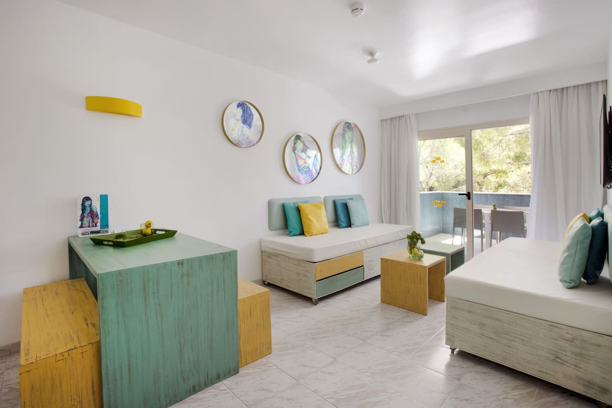 A modern living room with a sofa, a coffee table, and a dining area.