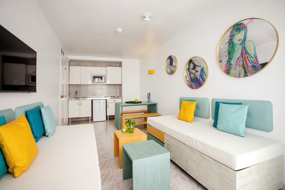 A modern apartment with a living area, kitchen, and dining space.
