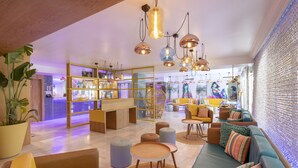 A modern lounge area with a bar, seating arrangements, and decorative lighting.