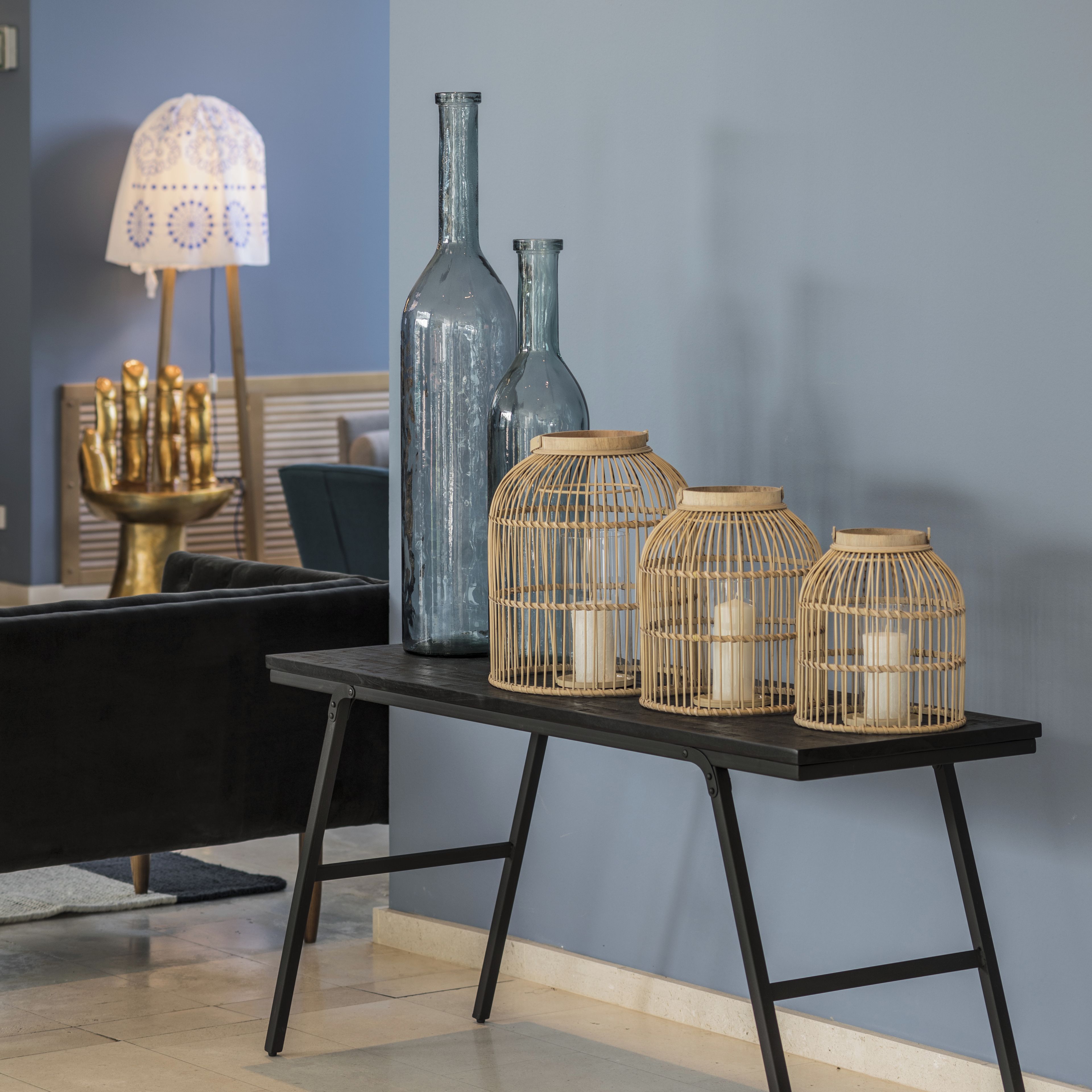 Una mesa con jarrones decorativos y candelabros frente a una pared.