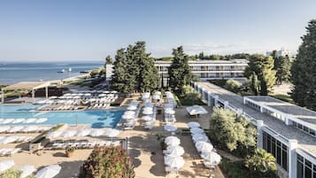 Piscine couverte, piscine extérieure, parasols de plage, chaises longues